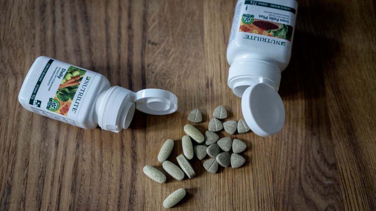 Top view of set of various medical pills arranged near plastic containers on wooden table
